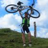 Frau hält Mounatinbike in die Höhe
